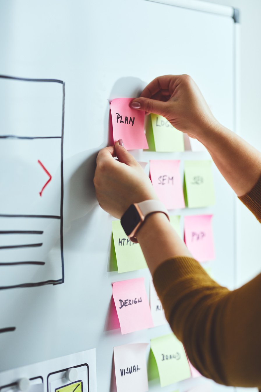 Woman web designer planning website ux app development on whiteboard